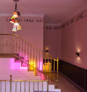 a staircase in a building with pink and yellow lights at freustil Hotel in Binz