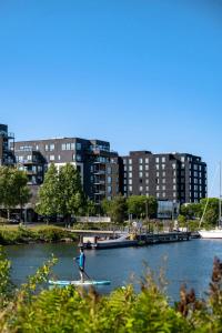 a person on a paddle board in a river with buildings at Delta Hotels by Marriott Thunder Bay in Thunder Bay