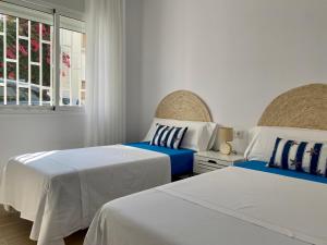 a bedroom with two beds and a window at Can Blau in Les Cases d'Alcanar
