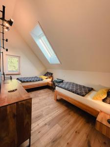two beds in a room with a skylight at Auwer Hills - On dr Schür in Auw