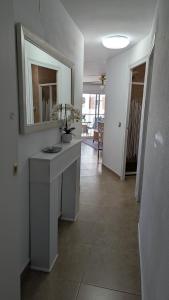 a white bathroom with a sink and a mirror at BELLAMAR 25 in Cambrils