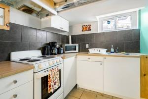 a kitchen with white cabinets and a stove top oven at The Rustic Barn in Brampton