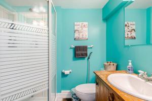 a blue bathroom with a toilet and a sink at The Rustic Barn in Brampton