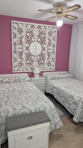 a bedroom with two beds and a ceiling fan at BELLAMAR 25 in Cambrils