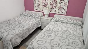 two twin beds in a bedroom with purple walls at BELLAMAR 25 in Cambrils +31 photos