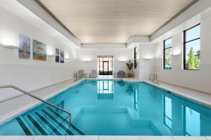 an indoor pool with blue water in a building at Residence Inn by Marriott Melville in Melville