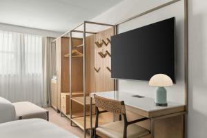 a bedroom with a desk with a tv on a wall at The Seahaus Hotel, Atlantic City Boardwalk, a Tribute Portfolio Hotel in Atlantic City