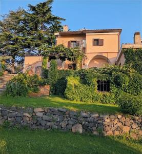 a large house with a stone wall in front at Tenuta Kiwi dell’Etna in Milo