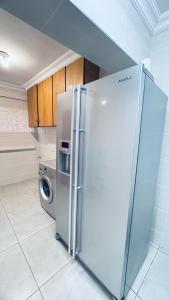 a stainless steel refrigerator in a kitchen with a washing machine at Casa Tranquila Luxe in Pretoria
