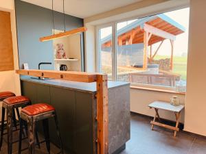 a kitchen with a large window and a counter with stools at Auwer Hills - On dr Schür in Auw