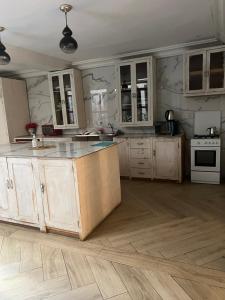 a kitchen with white cabinets and a wooden floor at MAISON Khadija Abibatou in Dakar