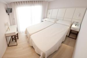 Postel nebo postele na pokoji v ubytování Hostal Loimar