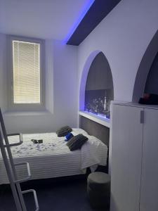a bedroom with a bed and an arched window at LuX Apartments in Lugo