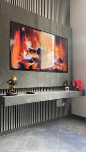 a fireplace in a living room with a tv on a wall at LuX Apartments in Lugo