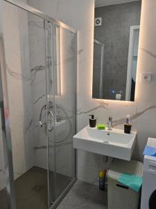 a bathroom with a glass shower and a sink at Divna-Besplatan parking in Banja Luka +18 photos