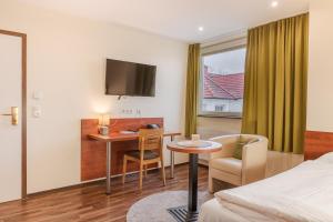 a hotel room with a bed and a table and a desk at Hotel Victoria in Hochheim am Main