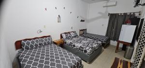 a room with two beds in a room with a bedskirts at Posada "Las Palmeras" in Dzilam de Bravo