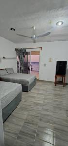 a bedroom with two beds and a ceiling fan at Posada "Las Palmeras" in Dzilam de Bravo