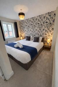 a bedroom with a large bed with floral wallpaper at Rudge House in Lichfield