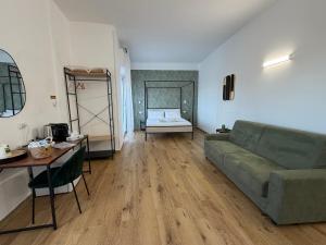 a living room with a couch and a bed at Cinquantotto Cozy Rooms in Palermo