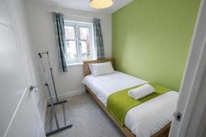 a small bedroom with two beds and a window at Rudge House in Lichfield