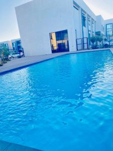 a swimming pool with blue water in front of a building at 7th Heaven luxury Apartment in Gaborone