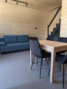 a living room with a table and a blue couch at Domki Słodka Magnolia in Karwia