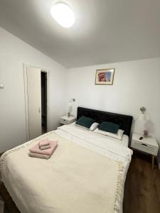a bedroom with a large bed with two towels on it at View Cozia in Călimăneşti