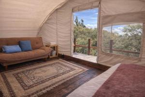 a room with a couch and a window in a tent at La Meca Glamping in Guasca