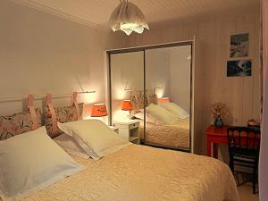 a bedroom with a bed and a large mirror at La p'tite Maison in Vitrac