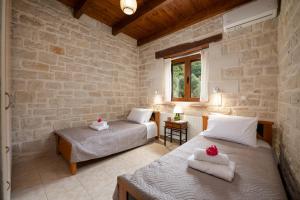 a bedroom with two beds and a window at Drys Stone House in Miriokéfala