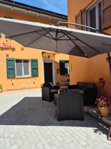 a patio with chairs and an umbrella in front of a building at Casa Martin 2 in Tolè