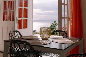 a black table with chairs and a glass vase on it at Gîtes Dardanelle in Bouillante +10 photos
