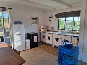 a kitchen with a white refrigerator and a sink at The STAL in De Rust
