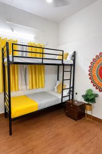 a room with two bunk beds with yellow curtains at Elite Hostel- SB Road Pune in Pune