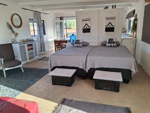 a bedroom with a large bed and a living room at The STAL in De Rust