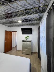 a room with a bed and a tv on a ceiling at Apartamentos el mochilero frente al mar piso 2 apto 3 in Cartagena de Indias