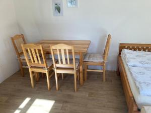 a dining room with a table and chairs and a bed at Apartment Panteon Basecamp in Malá Skála