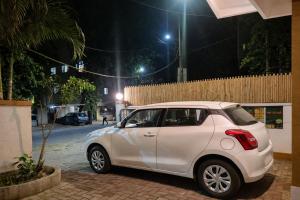 a white car parked on a brick street at night at Elite Hostel- SB Road Pune in Pune