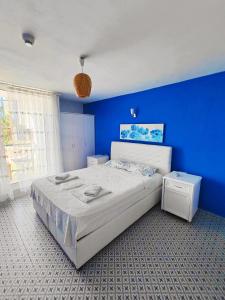 a blue bedroom with a bed and a blue wall at Mavi Akvaryum Pension in Sogut