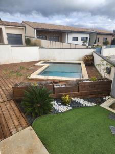 a backyard with a swimming pool and a house at Maison vacances avec piscine Pennautier in Pennautier