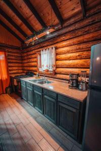 a kitchen with a sink in a log cabin at Mexiquillo - La Fogata - Cabin #5 in La Ciudad