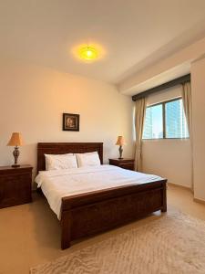 a bedroom with a large bed and a window at Spacious & classic Apartment in center of JBR in Dubai