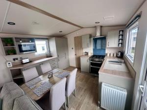 a kitchen with a table and chairs in a caravan at Blue dolphin static in Gristhorpe