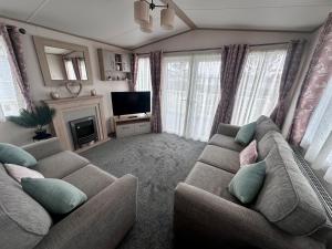 a living room with a couch and a television at Blue dolphin static in Gristhorpe