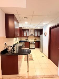a kitchen with wooden cabinets and a table in it at Spacious & classic Apartment in center of JBR in Dubai