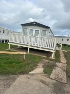 a white house with a bench in front of it at Blue dolphin static in Gristhorpe