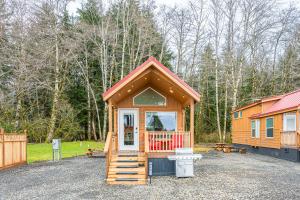a small cabin with a porch in a gravel lot at Rainforest Tiny Home Retreat #17 Abstract Modern in Forks