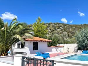 a villa with a swimming pool and a house at Villa Macky Cottage in Kato Almiri