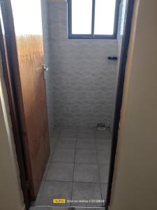 a small bathroom with a shower with a window at Luxury Homes in Mtwapa